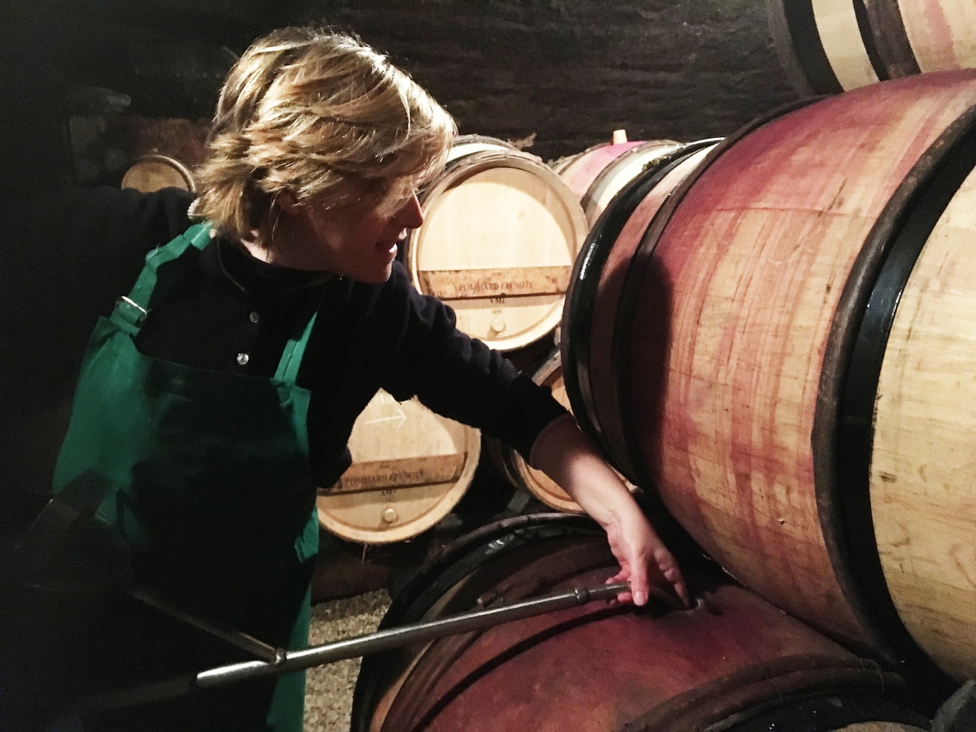 Annabelle Le Doledec, œnologue, devant un tonneau de vin – transmission et passion du vin avec Coup de Foudre